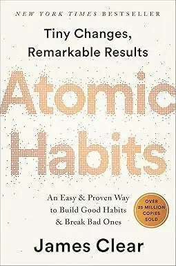 The book cover of atomic habits features a bold textured orange title on a light beige background