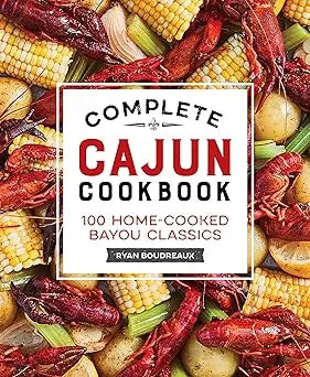 The complete cajun cookbook by ryan bourdeaux features a vibrant cover with red crawfish yellow corn and potatoes