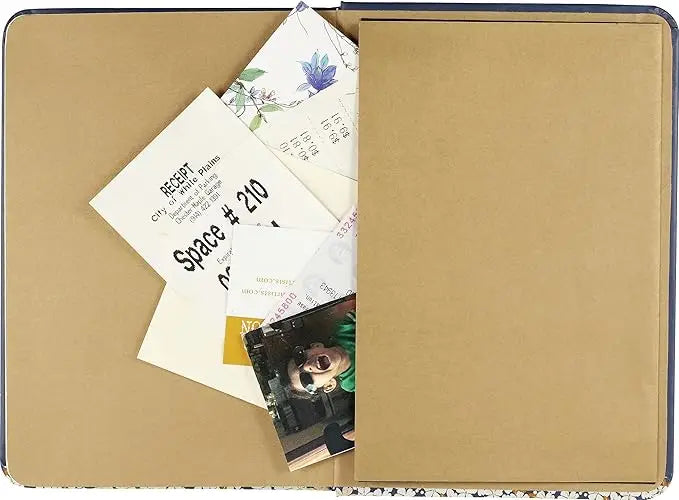 A navy blue falling blossoms journal with a delicate white flower and gold leaf illustration and matching elastic band