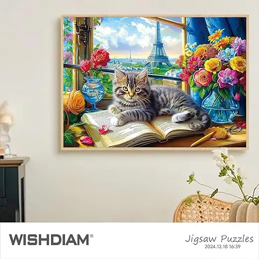 A 1000 piece jigsaw puzzle featuring a fluffy tabby kitten with yellow eyes on a book near flowers and the eiffel tower view