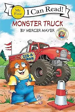Little Critter monster truck toy with a red body oversized black tires and a friendly lion character in overalls standing beside it