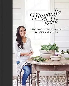 The magnolia table book cover shows a smiling woman in white blouse and blue jeans seated at a rustic wooden table