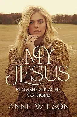 A woman with long blonde hair wearing a textured brown dress stands in a field for my jesus product display