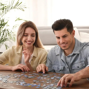 A woman and a man smiling as they assemble a rocorose 1000 piece puzzle for adults on a table