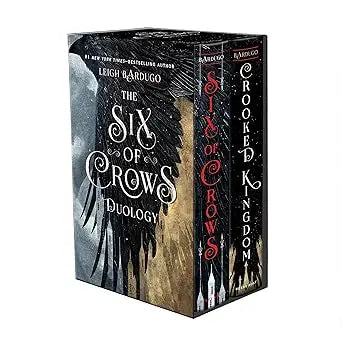 Six of crows boxed set featuring black and gold covers with intricate wing designs including six of crows and crooked kingdom