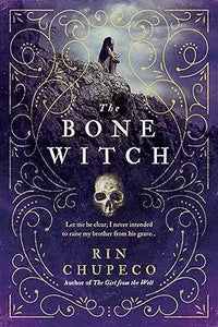 The bone witch book cover features an ornate dark purple design with gold filigree and a figure on a rocky outcrop