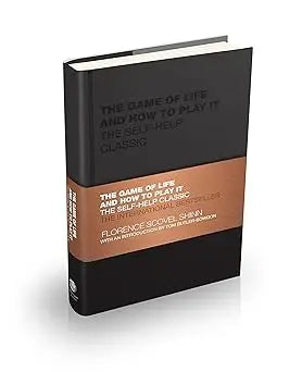 Black hardcover book the game of life and how to play it with matte finish and gold orange text on cover