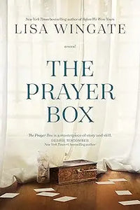 The prayer box is a hardcover novel with a minimalist white cover and elegant teal lettering by the author in black font