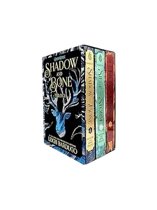 The shadow and bone trilogy boxed set with dark blue cover featuring silver stag design and gold lettering