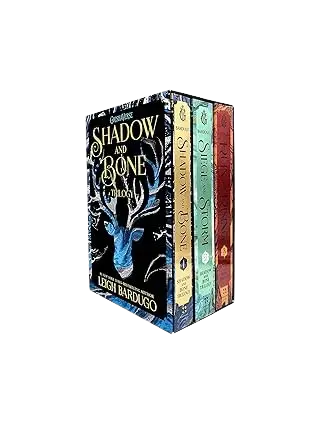 The shadow and bone trilogy boxed set with dark blue cover featuring silver stag design and gold lettering