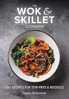 The wok and skillet cookbook features a vibrant stir-fry with colorful vegetables and noodles in a white bowl